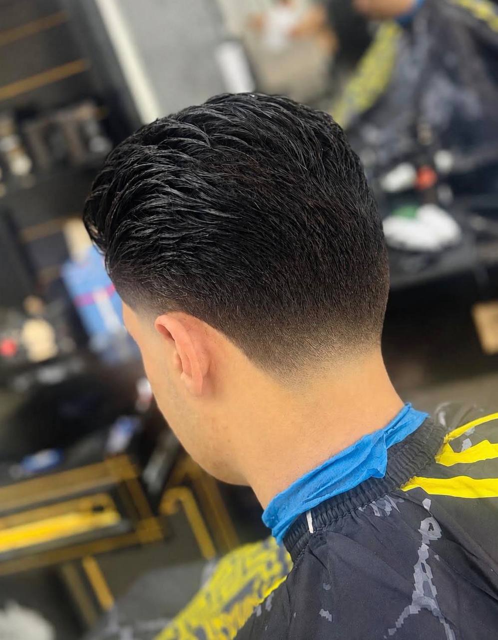 Strakke taper fade achterkant, geknipt bij Nobar Barber